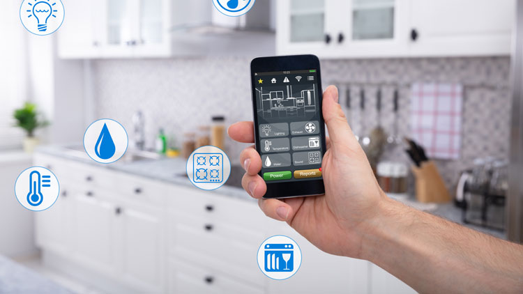 Hand, die in einer Küche ein Smartphone hochhält auf welchem eine Smarthome App installiert ist, Copyright Panthermedia