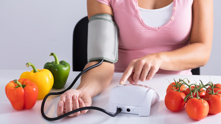 Frau misst Blutdruck, Paprika und Tomaten, Copyright Panthermedia