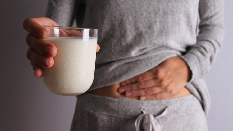 Frau hält Milchglas und fast sich an den Bauch, Copyright Panthermedia