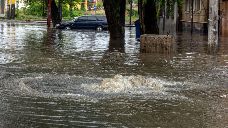 überschwemmte Straße in Stadt mit Auto; Coopyright Panthermedia