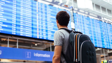 Das Bild zeigt einen Mann am Flughafen vor der Anzeigetafel; Copyright Panthermedia