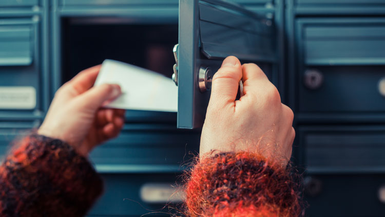 Person holt Briefe aus einem Postfach; Copyright Panthermedia