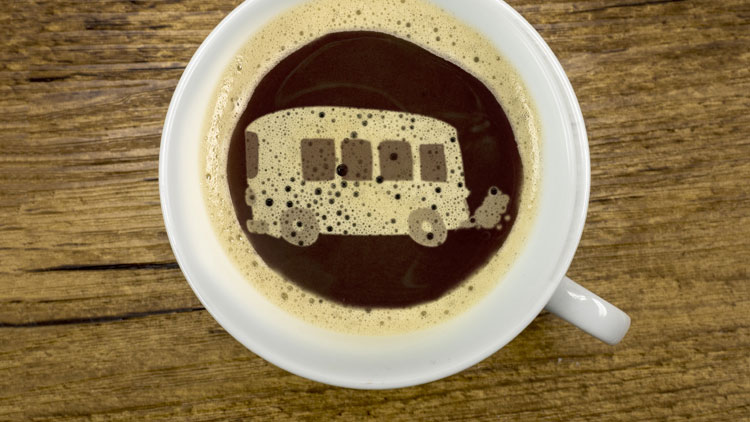 Kaffeetasse von oben mit Milchschaum, der einen Reisebus bildet; Copyright Panthermedia